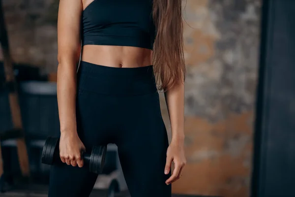 Young woman posing at the camera with dumbbells in her hands. — Stock Photo, Image