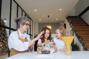 Büyükannem ve torunum mutfakta yemek pişiriyorlar..