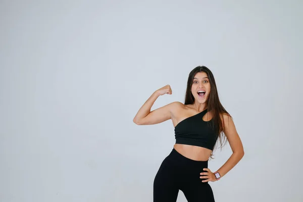 Alegre hermosa sonriente mujer deportiva demostrando bíceps — Foto de Stock