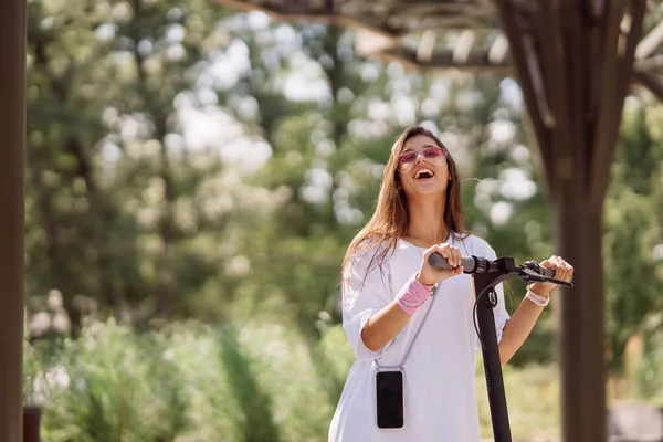 Joven hermosa mujer y un scooter eléctrico, transporte ecológico —  Fotos de Stock