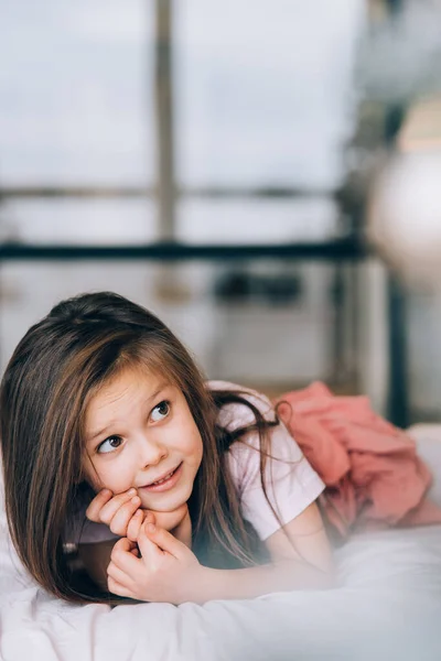 Little girl lying in the bed looking away. — Stock Photo, Image