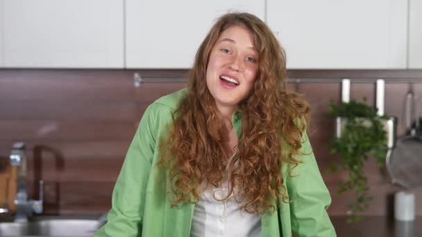 Närbild porträtt av en glad leende kvinna på köket tittar direkt på kameran — Stockvideo