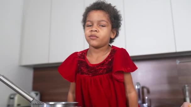 Primer plano retrato de alegre linda niña negra en la mesa en la cocina — Vídeos de Stock
