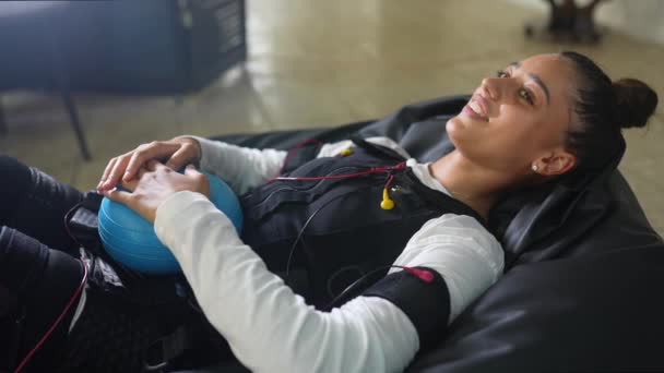 Entrenamiento en EMS. La chica yace en un traje con cables. — Vídeos de Stock