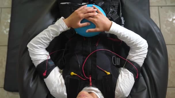 EMS pelatihan. Gadis itu berbaring di jas dengan kabel. — Stok Video