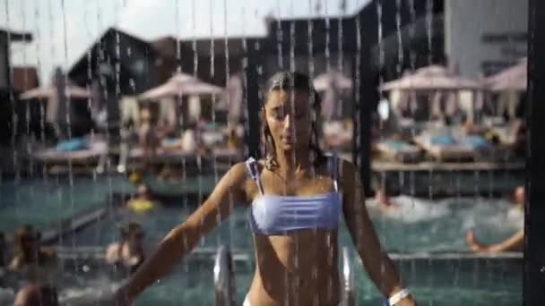 Menina bonita em roupa de banho Chuveiros sob a água na praia Resort. — Vídeo de Stock