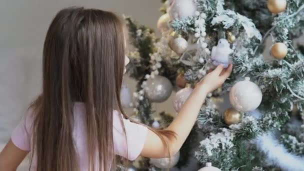 愛らしい女の子飾るAクリスマスツリーに家 — ストック動画