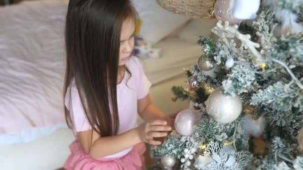 Adorable petite fille décorant un arbre de Noël à la maison — Video