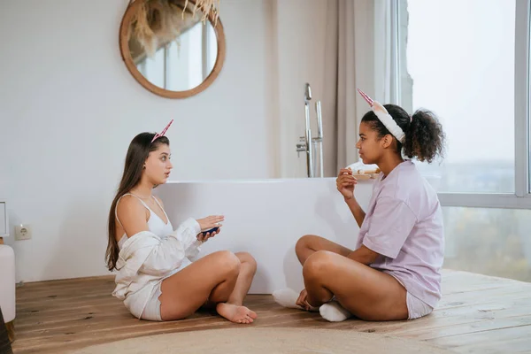 Två tjejer pratar på badrumsgolvet — Stockfoto
