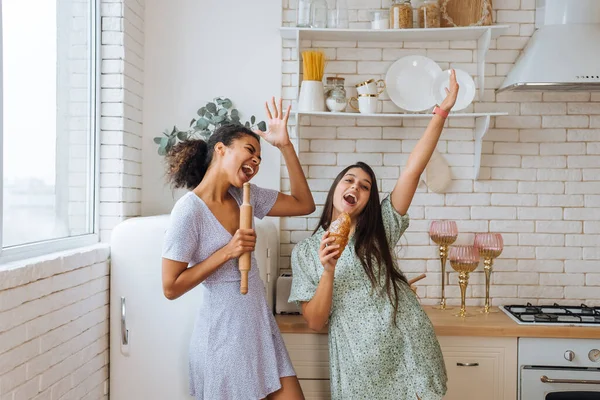 Duas meninas de raças diferentes se divertindo na cozinha — Fotografia de Stock