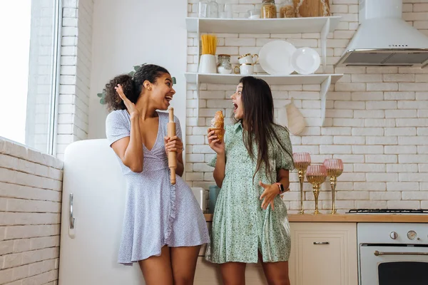 Dvě dívky různých ras se baví v kuchyni — Stock fotografie