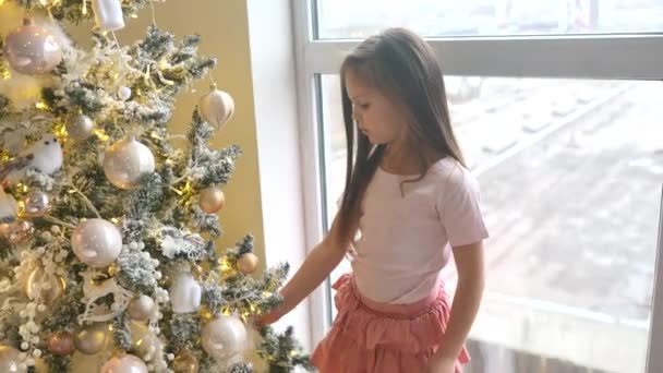愛らしい女の子飾るAクリスマスツリーに家 — ストック動画