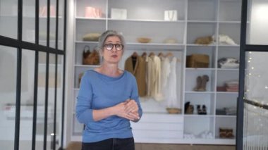 Yaşlı bir kadın kameraya bakıyor ve konuşuyor.