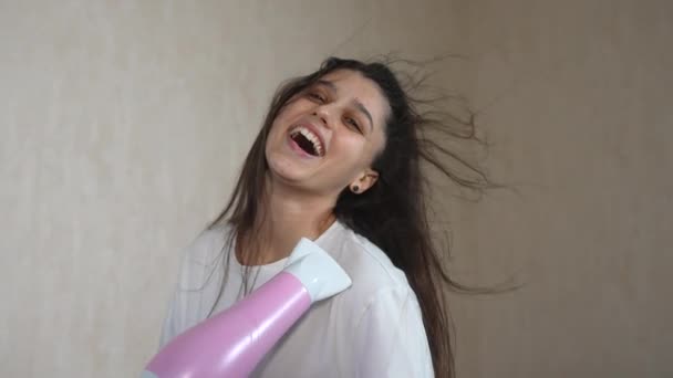 Saçını saç kurutma makinesiyle kurutan bir kadın. — Stok video