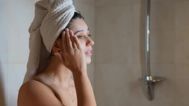 Крупним планом красива половина гола жінка наносить крем для обличчя — стокове відео