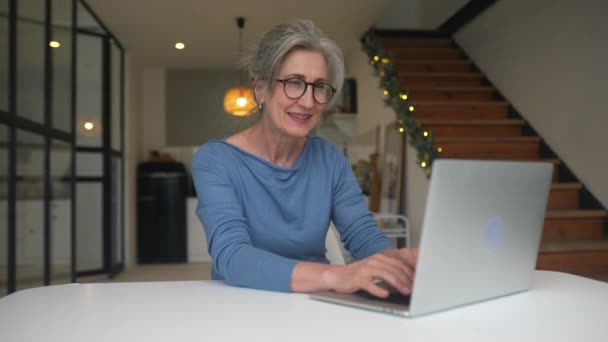 Glücklich reife ältere Frau mittleren Alters schaut auf Laptop — Stockvideo