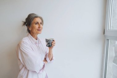 Rastgele giyinmiş yaşlı bir kadının portresi. Elinde bir kupa var.