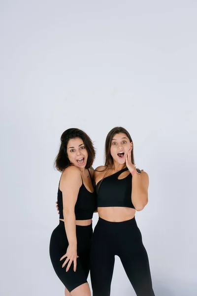 Twee jonge vrouwen poseren over witte achtergrond. — Stockfoto