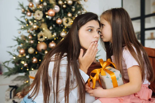 Genç anne üzgün küçük kızını sakinleştiriyor.