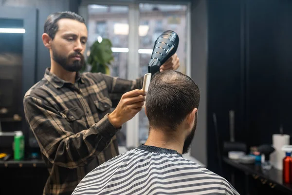 Mästaren i frisersalongen stylar klienternas hår. — Stockfoto