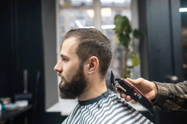 Maestro en barbería hace mens corte de pelo con cortador de pelo — Foto de Stock