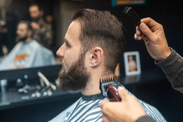 Master in barbershop makes mens haircutting with hair clipper — Stock Photo, Image