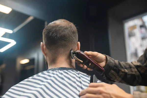 Master in barbershop makes mens haircutting with hair clipper — Stock Photo, Image