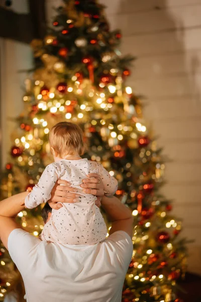 Føttene til en liten gutt i bakgrunnen av et juletre – stockfoto