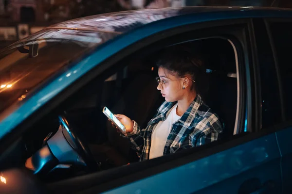 Conductor femenino perdido usando teléfono móvil mientras conduce por la noche. —  Fotos de Stock