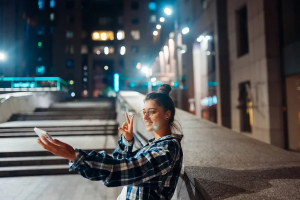 밤에 도시에서 비디오 통화를 하는 여성 — 스톡 사진