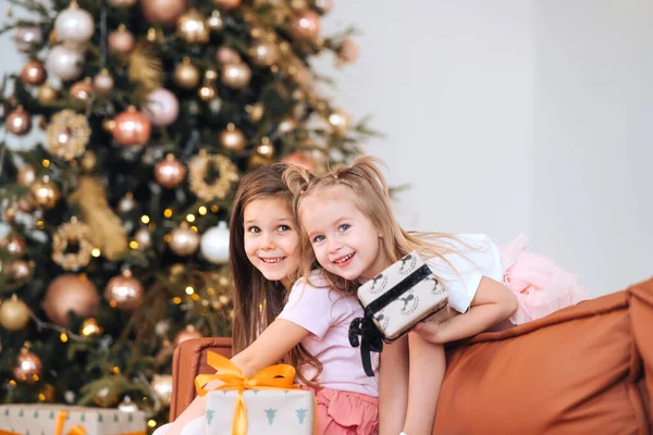 Дві дівчинки бавляться з подарунками "Нові роки" на дивані.. — стокове фото