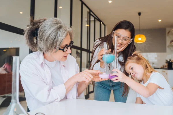 Aile kimyasal deney yapıyor, şişeleri evde karıştırıyor. — Stok fotoğraf
