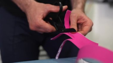 Fizyoterapist hazırlar ve kinesio taping keser.