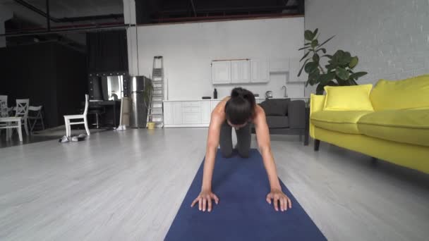Vacker ung kvinna gör övningar på golvet hemma — Stockvideo