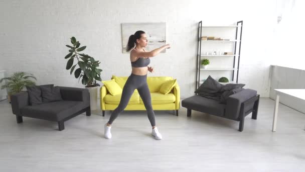 Hermosa mujer joven haciendo ejercicios abdominales en la habitación — Vídeos de Stock