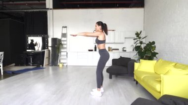 Güzel genç kadın odada karın egzersizi yapıyor.