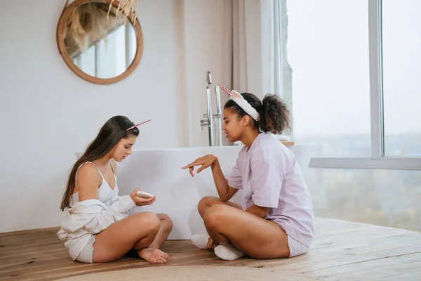 Två tjejer pratar på badrumsgolvet — Stockfoto