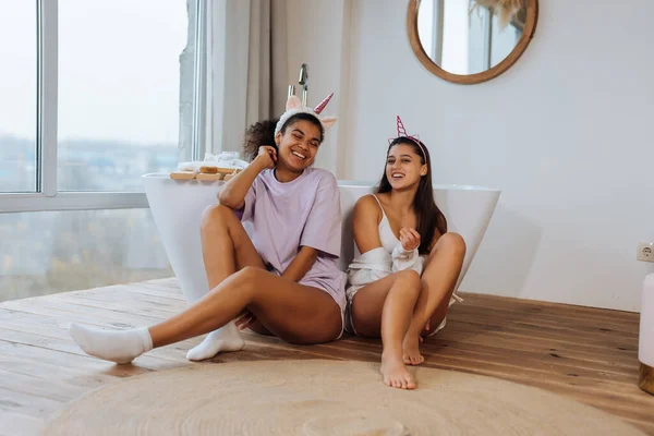 Две девушки разговаривают на полу в ванной — стоковое фото