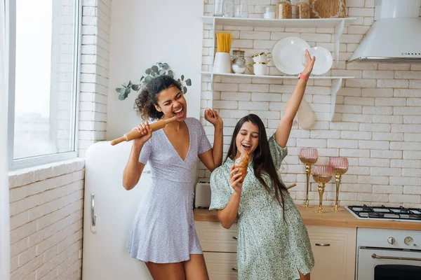 Duas meninas de raças diferentes se divertindo na cozinha — Fotografia de Stock