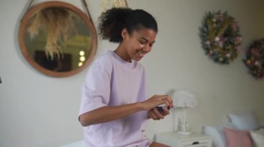 Afrikalı Amerikalı kadın cildine krem sürüyor.