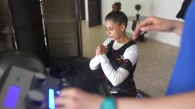 Acil servis eğitimi. Kablolu takım elbiseyle egzersiz yapan bir kız..