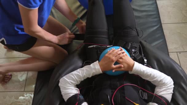 Обучение скорой. Девушка лежит в костюме с кабелями. — стоковое видео