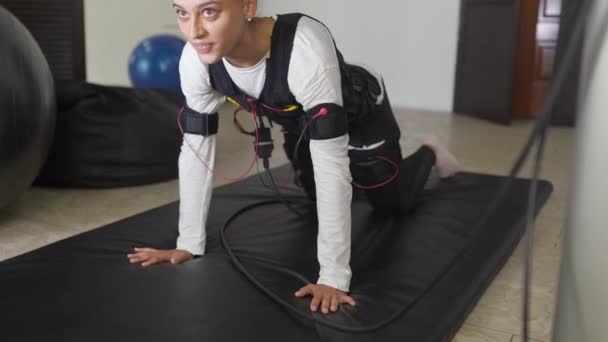 EMS-Ausbildung. Mädchen macht Übungen im Anzug mit Kabeln. — Stockvideo