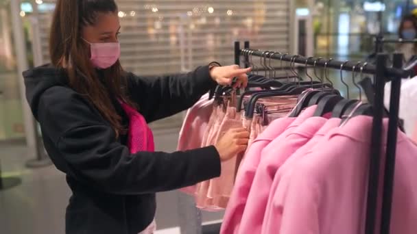 Mujer bastante joven de compras en la tienda de ropa — Vídeo de stock