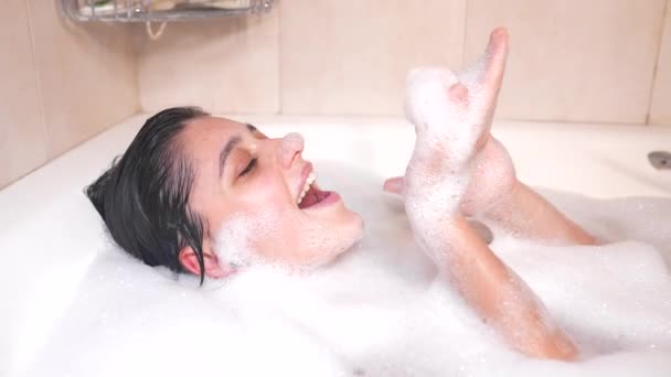Крупным планом расслабленной женщины касаются кожи с пеной в ванной. — стоковое видео