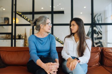 Evde büyükanneyi ziyaret eden genç bir kadın, kadınlar konuşuyor.