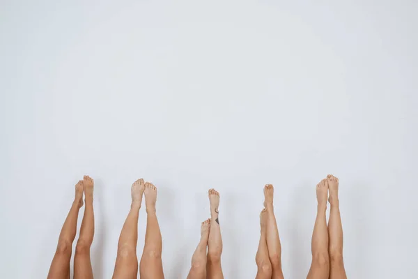 Γυναικεία πόδια που δείχνουν πάνω από λευκό φόντο — Φωτογραφία Αρχείου