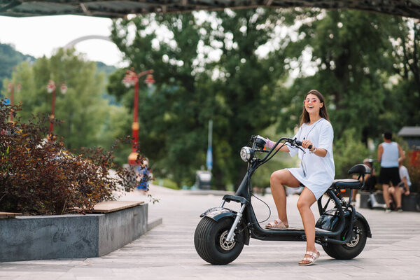Young beautiful woman and an electric scooter, ecological transport Royalty Free Stock Photos