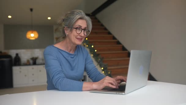 Счастливая пожилая женщина средних лет смотрит на ноутбук — стоковое видео