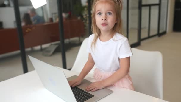 식탁에 앉아 있는 태블릿 컴퓨터를 사용하는 어린 소녀 — 비디오